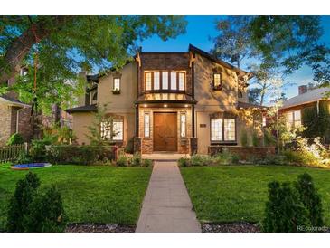 Charming two-story home with stone accents, landscaped yard, and a welcoming walkway leading to the front door at 718 Locust St, Denver, CO 80220