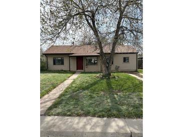 Charming single-story home featuring a well-maintained lawn, mature shade tree and a inviting red front door at 2865 S Fairfax St, Denver, CO 80222