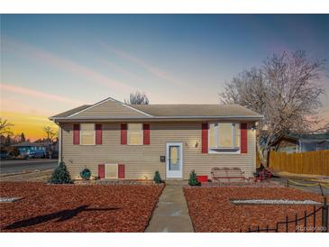 Beige ranch house with red shutters, landscaped yard, and a walkway at 381 El Paso Ct, Denver, CO 80221