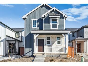 Charming two-story home boasts stone accents, covered porch, and a well-maintained front yard at 2031 Generations Aly, Brighton, CO 80601