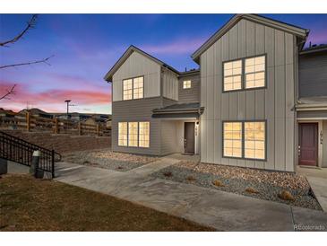 Charming townhome featuring a modern two-tone exterior and well-manicured landscaping at 16798 W 94Th Way, Arvada, CO 80007