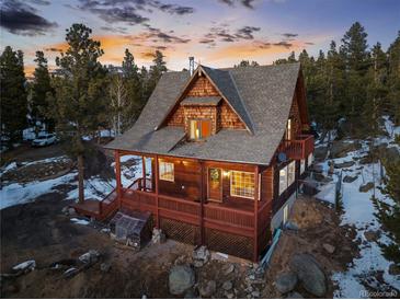 Charming cabin-style home with a spacious wrap-around deck, nestled amongst the trees with beautiful sunset views at 439 Ronnie Rd, Golden, CO 80403