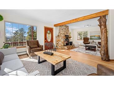 Living room with stone fireplace, hard wood floors, and beautiful views at 439 Ronnie Rd, Golden, CO 80403