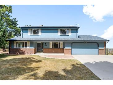 Charming two-story home boasts a well-manicured lawn and a welcoming brick facade at 12579 Appaloosa Pl, Broomfield, CO 80020