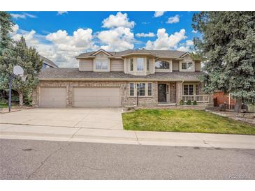 Charming two-story home with a three-car garage, brick facade, and a well-manicured front yard at 5668 S Rifle Ct, Centennial, CO 80015