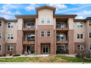 Inviting three-story condo building featuring brick accents and private balconies for outdoor enjoyment at 15345 W 64Th Ln # 107, Arvada, CO 80007