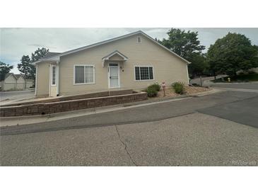 Inviting home featuring a well-maintained exterior with lovely landscaping, and a charming entrance at 12235 E 2Nd Dr, Aurora, CO 80011