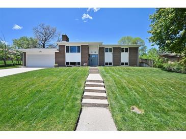Inviting home showcasing a well-manicured lawn and a charming walkway to the front door at 1733 S Urban Way, Lakewood, CO 80228