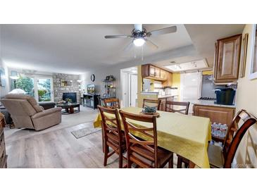 Inviting living area boasts a stone fireplace and seamless flow into the adjacent dining space at 491 S Kalispell Way # 305, Aurora, CO 80017