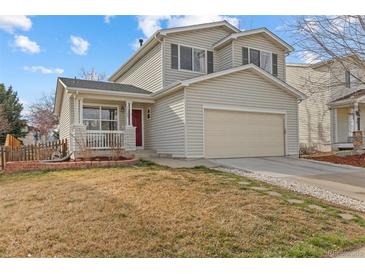 Charming two-story home featuring a two-car garage, red front door, and inviting front porch at 1189 Fall River Cir, Longmont, CO 80504