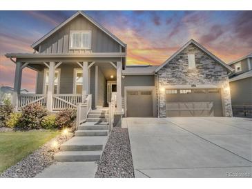 Charming two-story home with a stone accent, covered porch, manicured lawn and two-car garage at 5045 Preserve Pl, Firestone, CO 80504