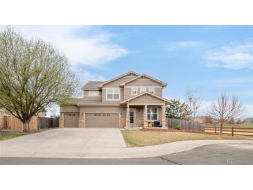 Charming two-story home featuring a three car garage, mature trees and manicured lawn in a suburban neighborhood at 21062 E Mansfield Pl, Aurora, CO 80013