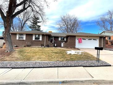 Brick ranch home with attached garage and landscaped yard at 2747 S Otis St, Denver, CO 80227