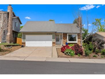 Charming single-story home with a well-manicured lawn and attached garage at 18771 Mexico E Dr, Aurora, CO 80017