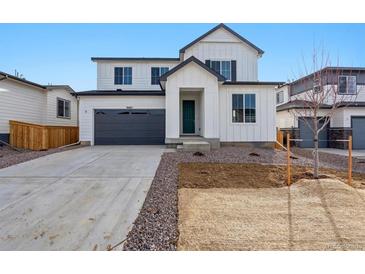 Modern two-story home with a gray garage door, newly landscaped front yard, and a welcoming entryway at 9062 Telluride Ct, Commerce City, CO 80022