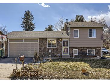 Charming split-level home with a brick and tan exterior, plus an attached two-car garage at 11002 E Ohio Pl, Aurora, CO 80012