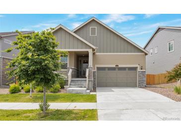 Charming two-story home with a well-manicured front yard, a covered porch and a two car garage at 24314 E Ford Ave, Aurora, CO 80018