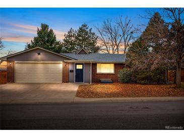 Brick ranch home with attached garage and landscaping at 6443 Reed Ct, Arvada, CO 80003