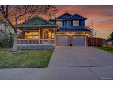 Charming two-story home featuring a covered porch and a two-car garage with a long driveway at 5457 S Valdai St, Aurora, CO 80015