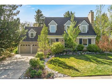 Charming brick home with manicured lawn, mature trees, and an attached two-car garage at 7770 S Ivy Way, Centennial, CO 80112