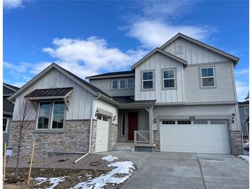 Charming two-story home with stone accents, a red front door, and a three-car garage on a sunny day at 651 Sunrise St, Erie, CO 80516