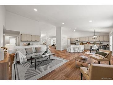 Bright living space with hardwood floors, modern furnishings, and an open concept to the kitchen at 5554 S Ward Way, Littleton, CO 80127