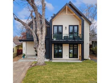 Stunning modern home with a white brick facade, black accents, balcony, and professionally landscaped yard at 1675 S Steele St, Denver, CO 80210