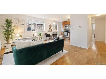 Open living room with hardwood floors and teal couch at 1419 Detroit St # 25, Denver, CO 80206