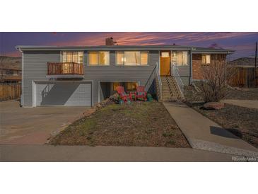 Charming home featuring a split-level design, garage, and quaint front porch seating area at 16805 W 16Th Pl, Golden, CO 80401