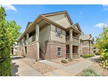 Attractive multi-level condo with inviting brick facade, private balconies, and manicured landscaping at 23346 E 5Th Pl # 101, Aurora, CO 80018