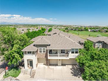 Well-maintained townhouse featuring a balcony, two-car garage, and manicured landscaping at 12912 Grant Cir # A, Thornton, CO 80241