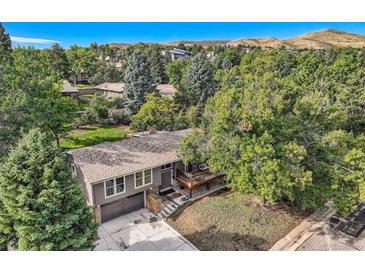Stunning home with mature trees, a gray exterior and a covered deck at 13610 W Dakota Pl, Lakewood, CO 80228