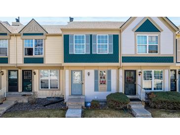 Charming townhome featuring a blue front door, updated windows, and well-maintained landscaping at 1621 S Idalia Cir # D, Aurora, CO 80017
