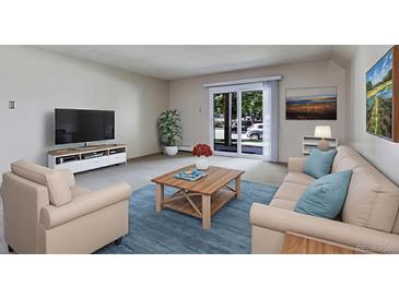 Comfortable living room featuring a plush sofa, armchair, and a coffee table on an area rug at 13606 E Bates Ave # 102, Aurora, CO 80014