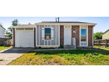Charming single-story home features brick and siding, attached garage, and a well-maintained front yard at 5112 Duluth Ct, Denver, CO 80239