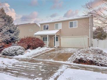 Two-story house with attached garage and snow-covered landscaping at 21621 Stoll Pl, Denver, CO 80249