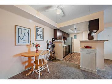 Charming kitchen with stainless steel appliances and a cozy dining area at 13393 E Asbury Dr # 103, Aurora, CO 80014