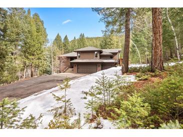 Secluded mountain home with attached three-car garage and stunning wooded surroundings, offering privacy and convenience at 5575 Jackpine Rd, Evergreen, CO 80439