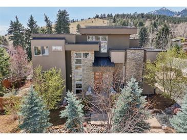 Stunning modern home showcasing stone accents, large windows, and professional landscaping in a natural setting at 350 15Th St, Boulder, CO 80302