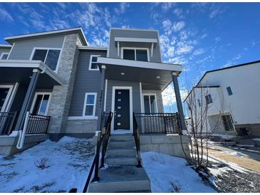 Modern two-story home with gray siding and stone accents, welcoming front porch, and steps leading to the entrance at 22841 E Stanford Ln # A, Aurora, CO 80015