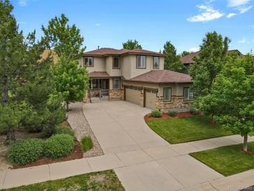 Spacious two-story home features a three car garage, manicured lawn and beautiful stone and wood accents at 24269 E Arapahoe Pl, Aurora, CO 80016