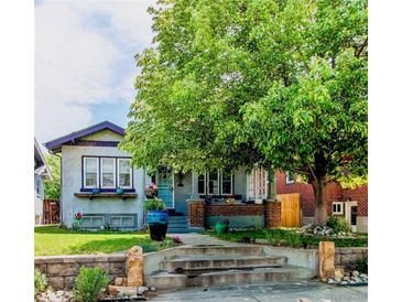 Charming two-story home with a large tree and nicely landscaped front yard at 1844 S Lincoln St, Denver, CO 80210