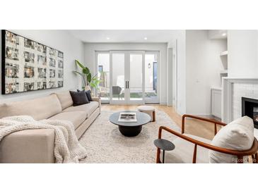 Bright living room featuring light wood floors, large windows, modern decor, and comfortable seating at 556 Monroe St, Denver, CO 80206