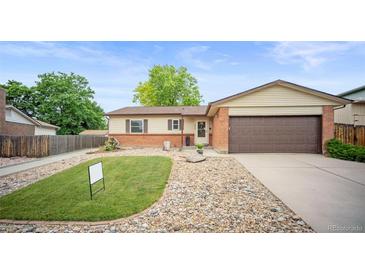 Charming ranch home with brick accents, a well-kept lawn, and an attached two-car garage at 7659 S Holland Way, Littleton, CO 80128