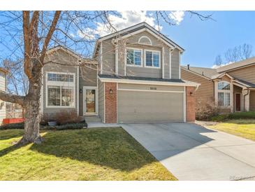 Charming two-story home with a well-maintained lawn and a two-car garage at 9230 W Indore Dr, Littleton, CO 80128