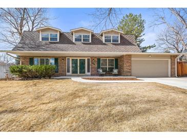 Charming brick home featuring a well-manicured lawn and a cozy front porch seating area at 7197 S Newland St, Littleton, CO 80128