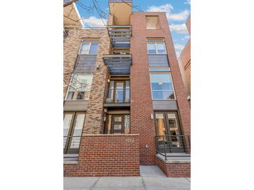Modern brick condo with metal accents on a sunny day at 1012 Bannock St, Denver, CO 80204