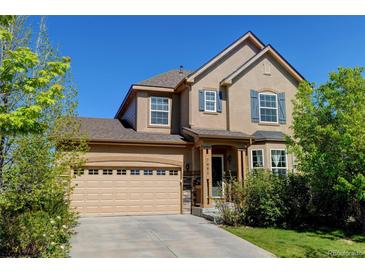 Charming two-story home featuring a well-manicured lawn and attached two car garage at 7081 S Oak Hill Cir, Aurora, CO 80016