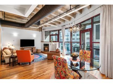 Bright living room featuring hardwood floors, a fireplace, and large windows with city views at 1020 15Th St # 214, Denver, CO 80202