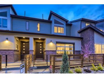 Charming townhome featuring a modern design, beautiful brick accents, and a well-maintained landscaped front yard at 12329 W 58Th Ct, Arvada, CO 80004